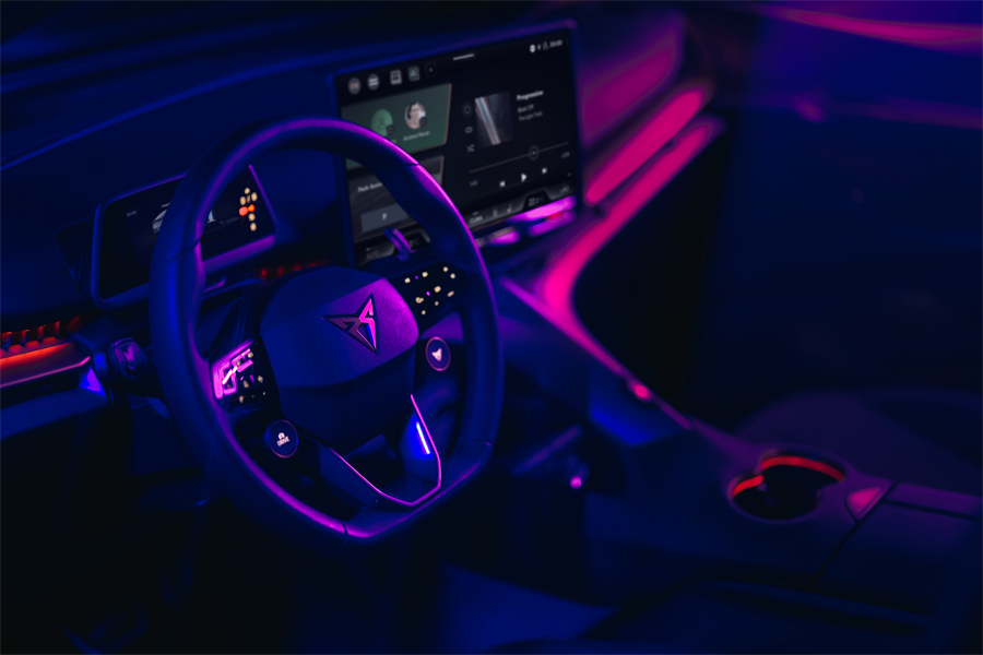 Interior de Cupra Tavascan con las luces ambientales destacadas y las pantallas infoentretenimiento
